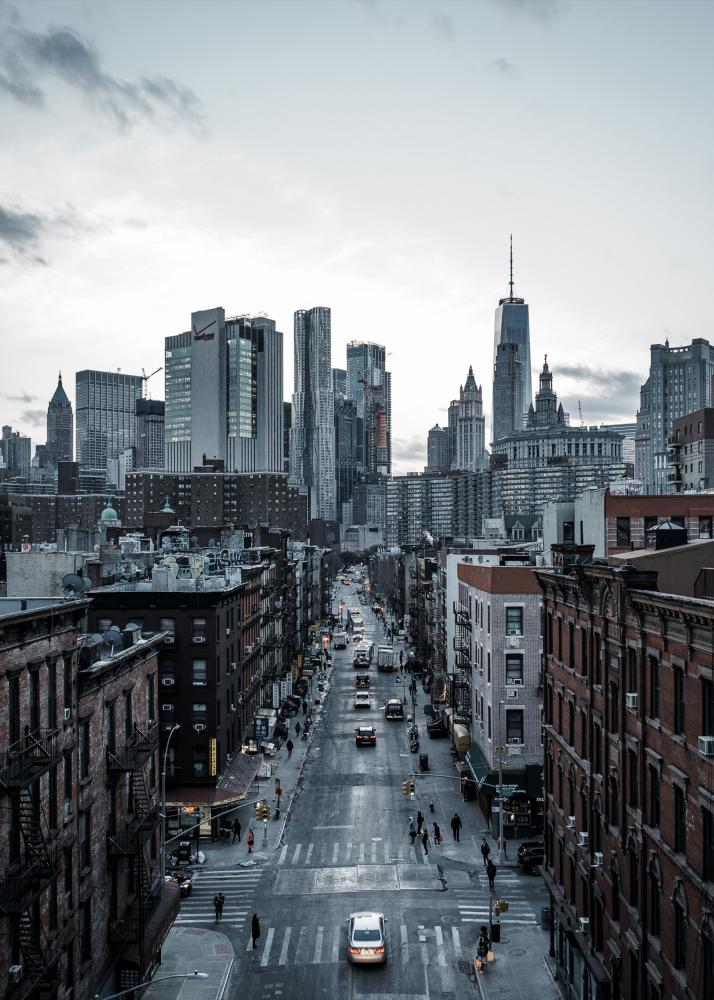 Eine belebte Stadtstraße mit Hochhäusern und Wolkenkratzern, die sich in den Himmel erheben.