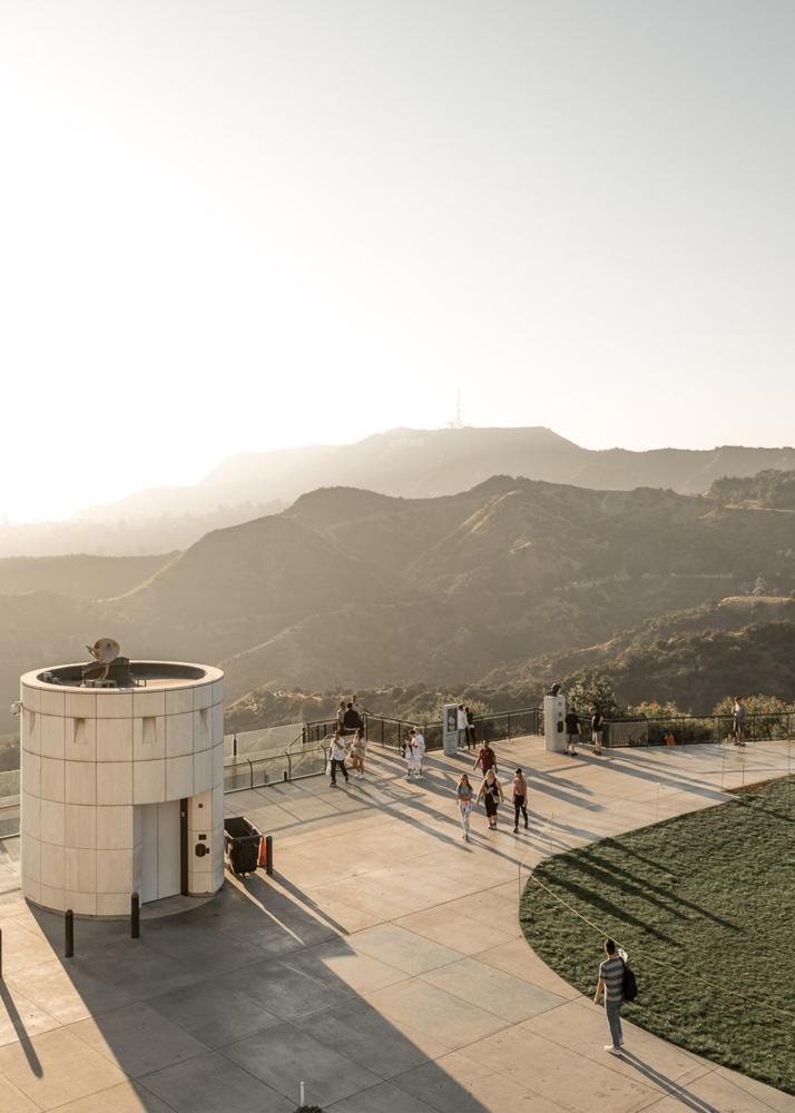 Ein Aussichtspunkt mit einem runden Turm und Besuchern, die die Aussicht auf eine bergige Landschaft genießen.