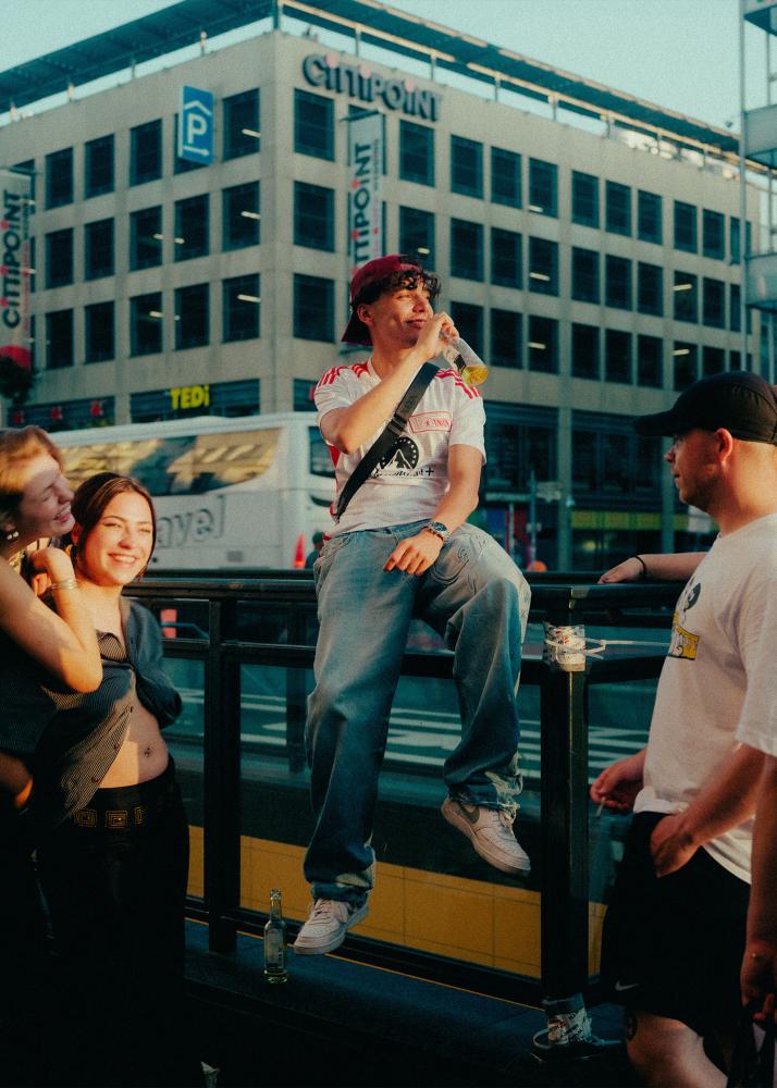 Vier junge Erwachsene genießen die letzten Sonnenstrahlen in einer Großstadt.