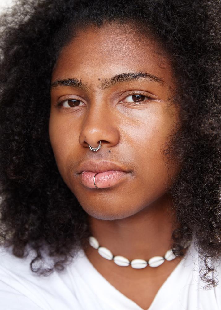 Portrait einer Frau mit Muschel-Kette und Nasen-Schmuck.