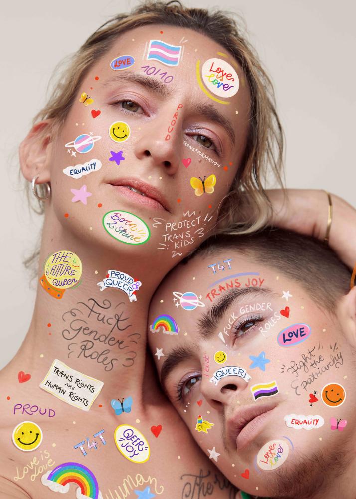 Portrait zweier Personen, von denen die eine ihren Kopf auf die Schulter der anderen legt. Beide Personen haben bunte Sticker über ihre Gesichter verteilt.