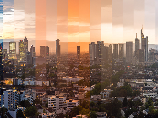 Ein Panorama einer Großstadt bei Sonnenuntergang, mit Hochhäusern und einem klaren Himmel.