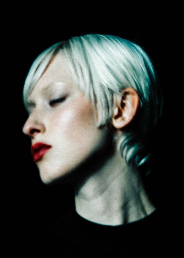 Ein dunkel gekleideter Mann läuft durch die weißen, kargen Wände eines U-Bahnhofes.