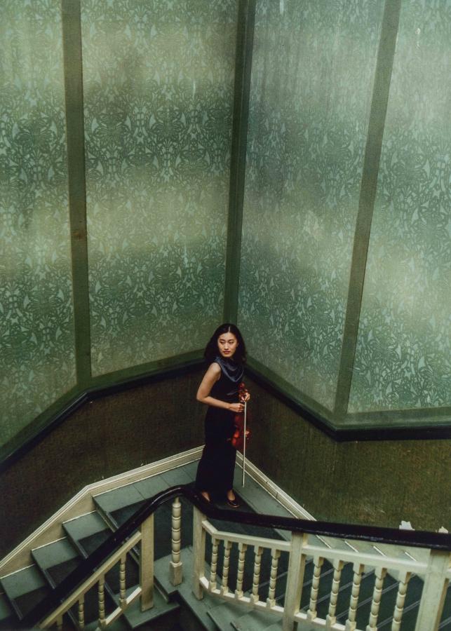 Hohe Häuser einer Großstadt und mehrere Personen im Vordergrund in schwarz und weiß.