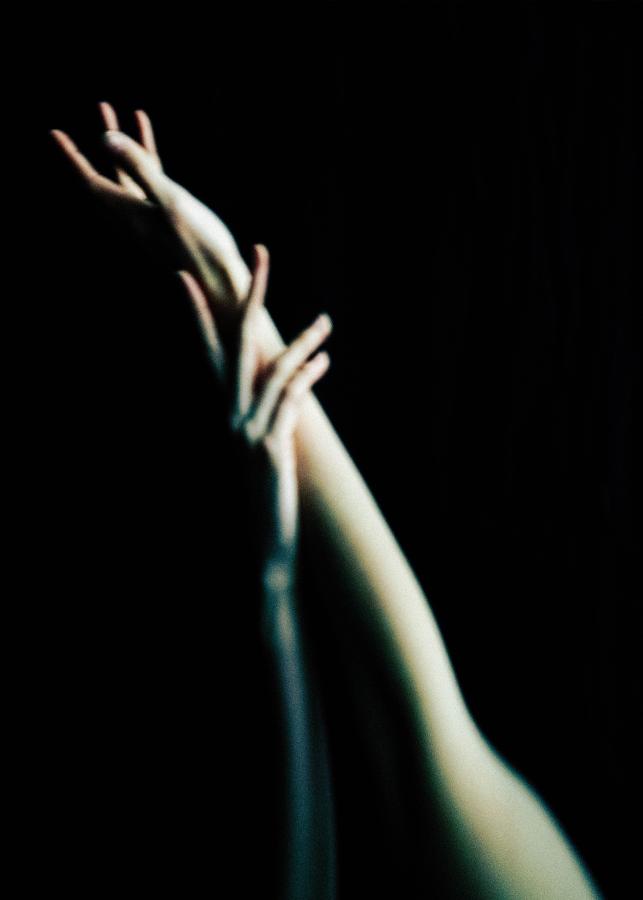 Zwei Männer unterhalten sich intensiv vor der hellen, sonnenbeschienenen Fassade eines Hauses. Mit Licht- und Schattenspiel in Schwarz und Weiß.