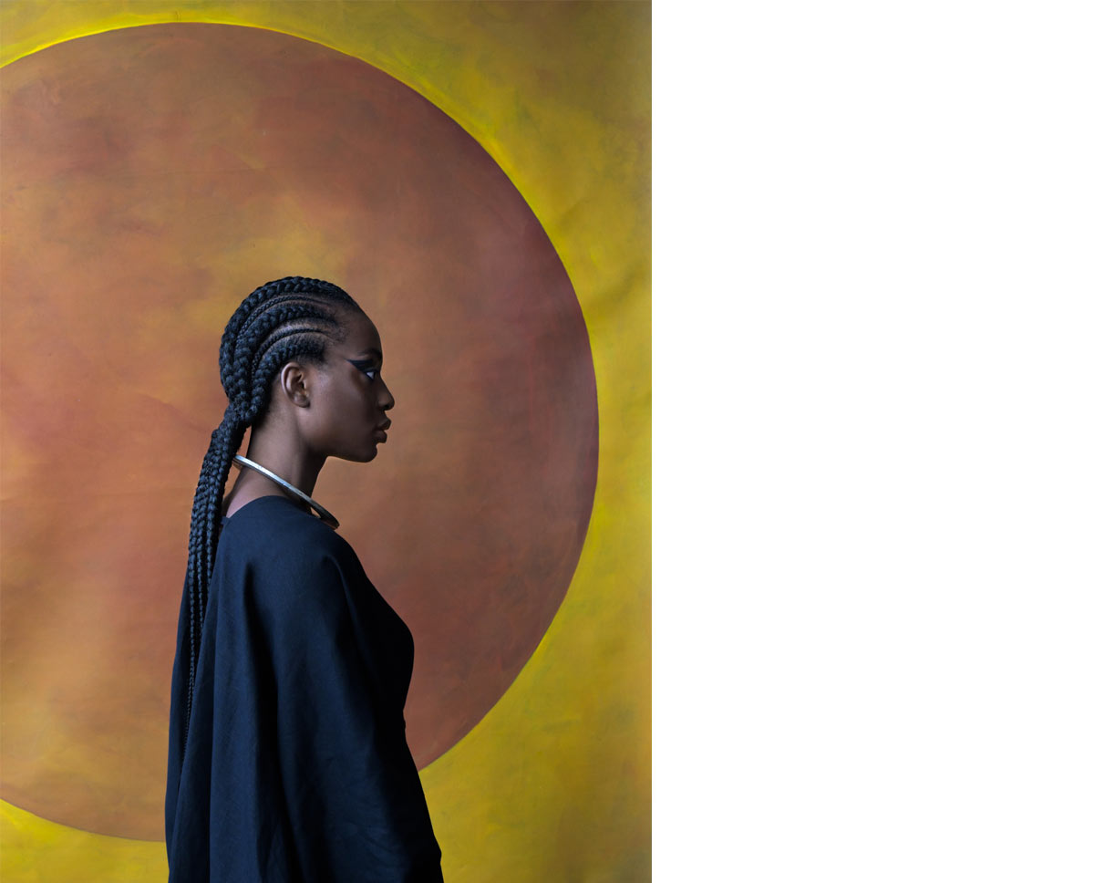 Seitenprofil einer Frau mit langen geflochtenen Haaren und einem silbernen Halsreif.