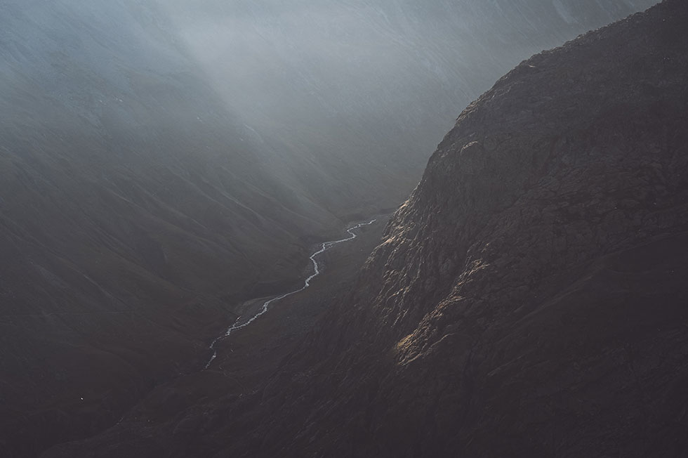 Diffuses Sonnenlicht scheint in eine tiefe Schlucht, in der ein Fluss fließt.