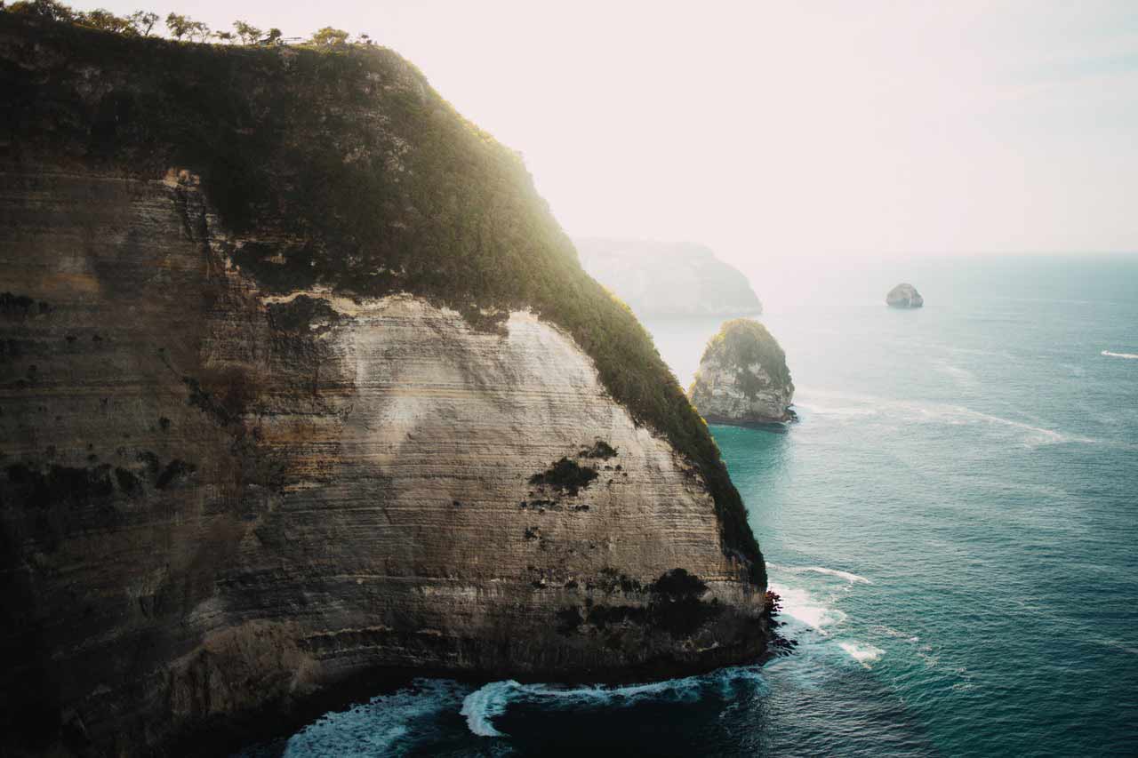 Große Felsvorsprünge die sich über dem türkisen Meer erheben.