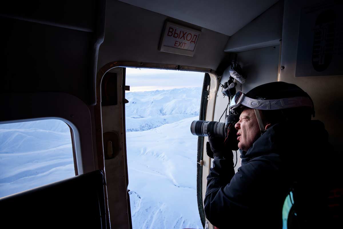 Ein Fotograf fotografiert aus der offenen Tür eines Flugobjekts.